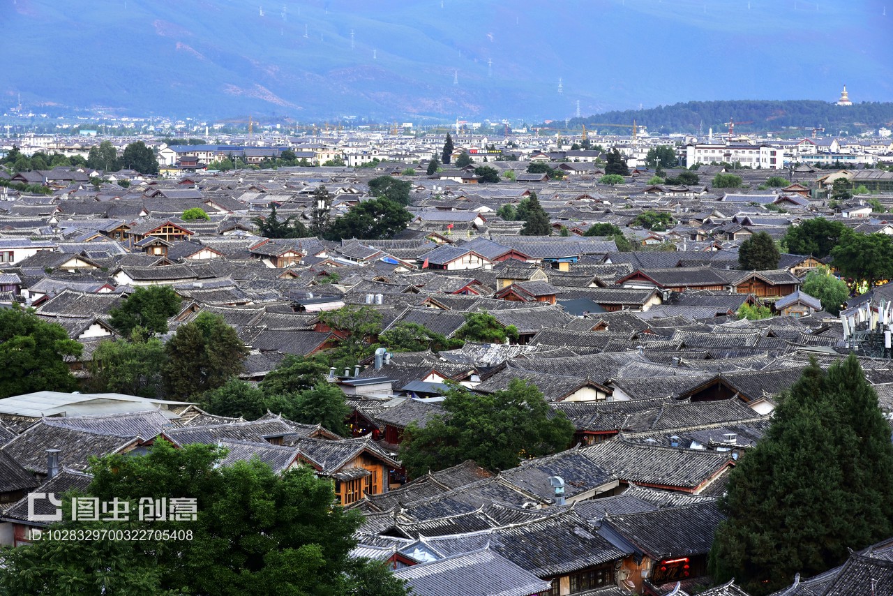 中國(guó)云南省麗江市麗江古城,傍晚,古城全景,夕陽(yáng)西下,納西族建筑的屋頂和遠(yuǎn)山,映在太陽(yáng)光下。